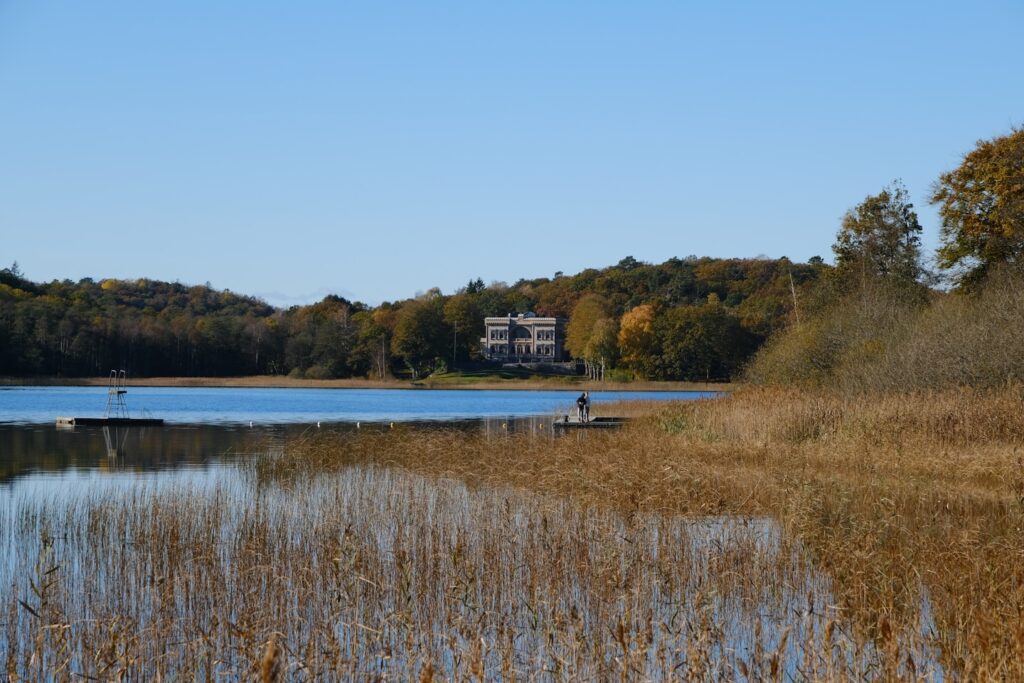 A building on a hill overlooking a lake