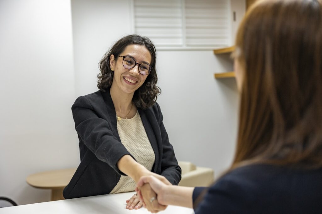 Young Woman in Business Attire Shaking Hands With Recruiting Manager After Job Interview