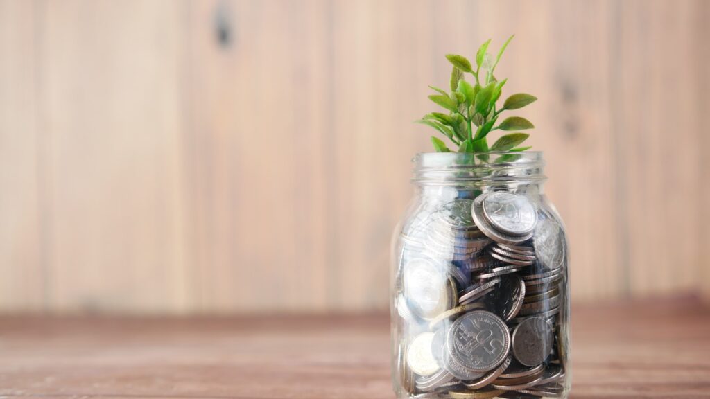 Bocal de pièces avec une plante, symbole de l'épargne qui fructifie